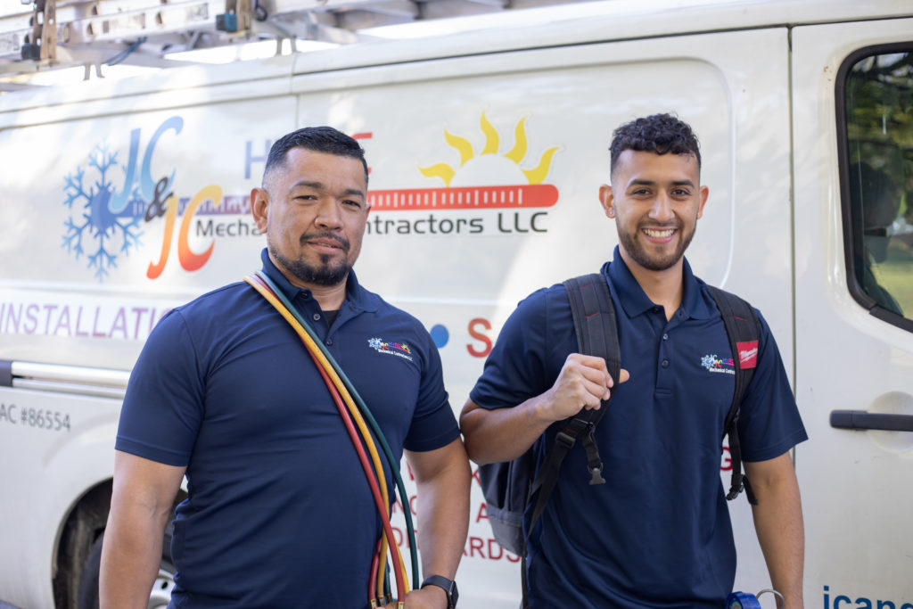 Two technicians from JC & JC HVAC Mechanical Contractors ready to perform an HVAC service.