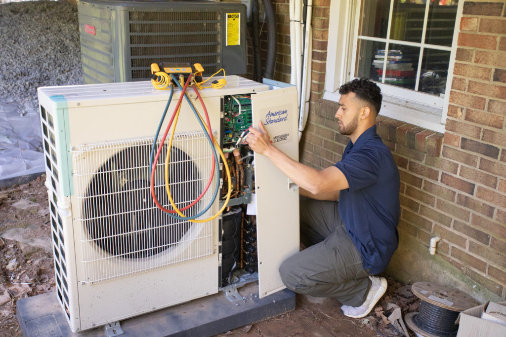 A technician from JC & JC HVAC Mechanical Contractors performing an AC repair.